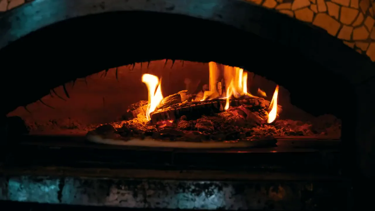 Il fuoco di un forno a legna nella cucina di un ristorante